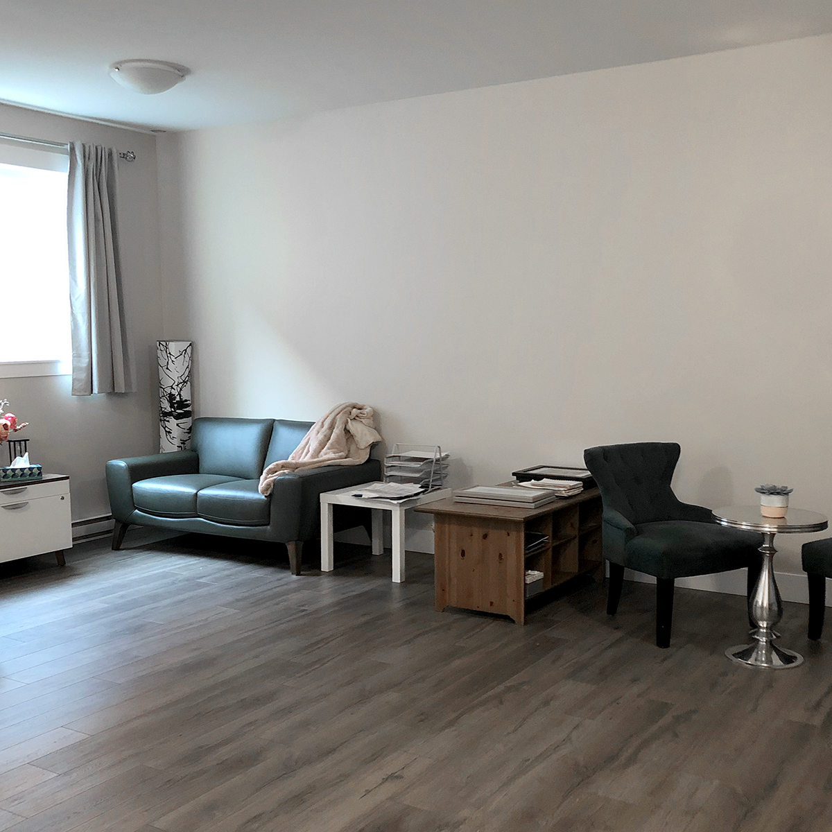 Wide view of the counselling studio at Tanglewood, with a seating area and desk against the far wall